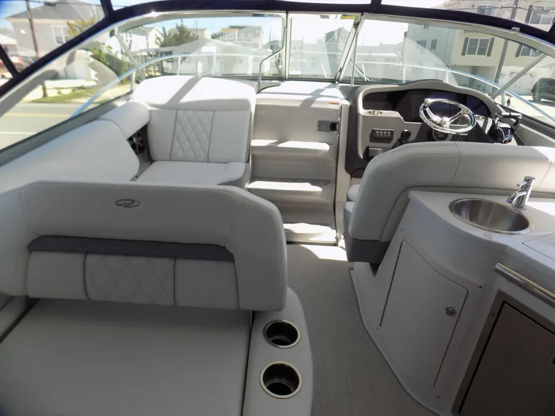 Slide: The Image of 2022 Regal 33 XO boat interior with seating, steering wheel, and sink. - 5