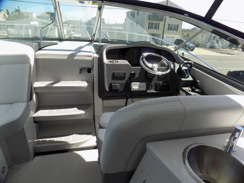 Slide: The Image of 2022 Regal 33 XO boat interior with helm, steering wheel, and seating area. - 8