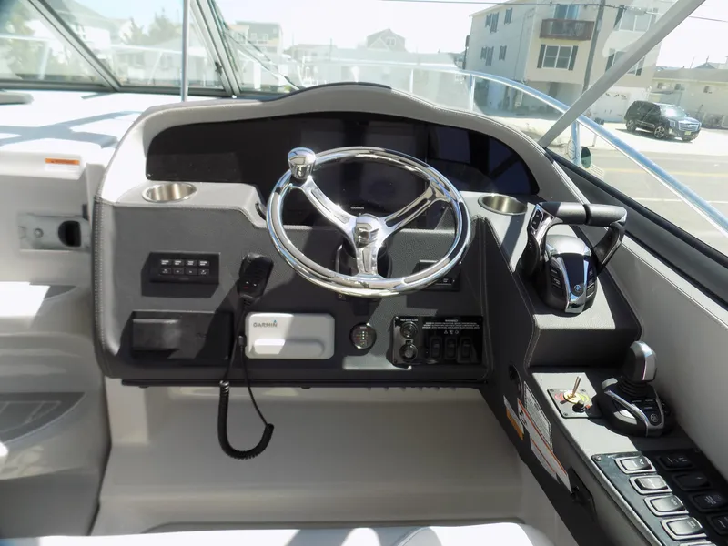 Slide: The Image of 2022 Regal 33 XO boat helm with steering wheel and control panel. - 9