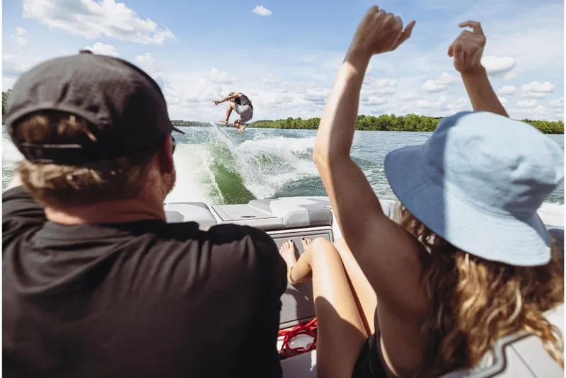 Slide: The Image of People enjoying wakeboarding behind a 2023 MasterCraft XT24 boat on a sunny day. - 10