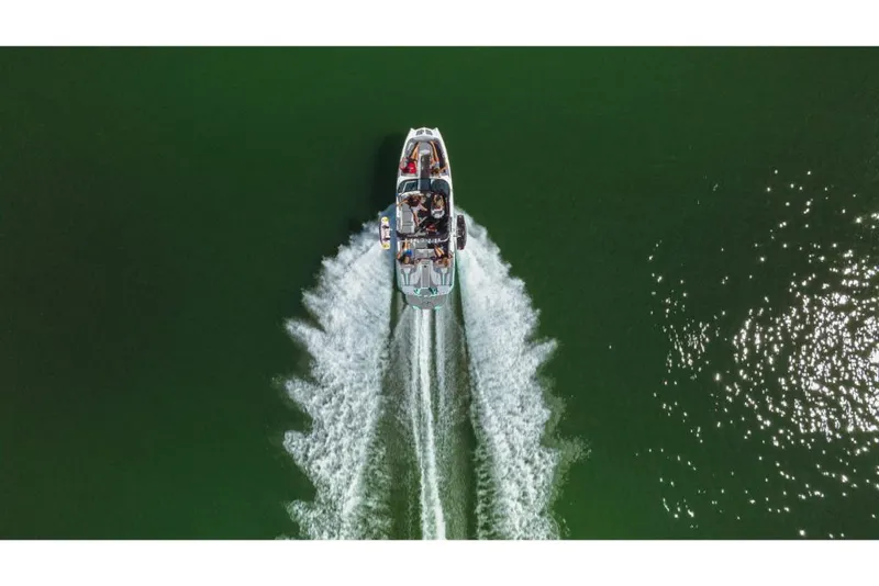 Slide: The Image of Aerial view of 2023 MasterCraft XT24 boat cruising on green water. - 28