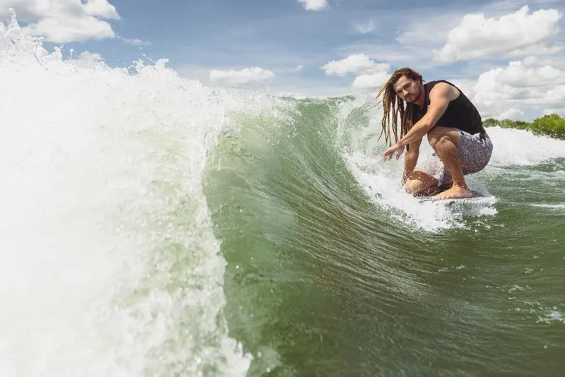 Slide: The Image of Man wakesurfing behind 2023 MasterCraft XT24 boat on a sunny day. - 29