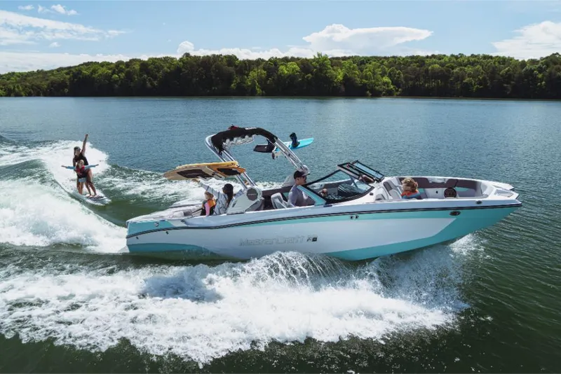 Slide: The Image of 2023 MasterCraft XT24 boat on a lake with people wakeboarding. - 30