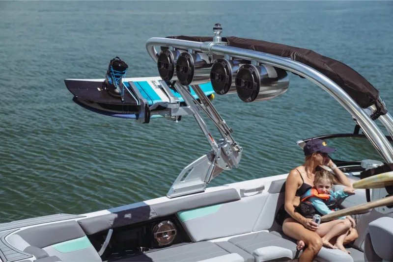Slide: The Image of 2023 MasterCraft XT24 boat with wakeboard tower and family onboard. - 32