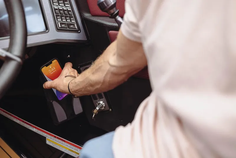 Slide: The Image of Man placing phone in 2023 MasterCraft XStar S boat console. - 10