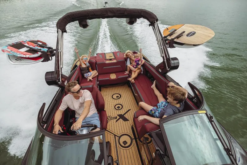Slide: The Image of 2023 MasterCraft XStar S boat with family enjoying water activities. - 3