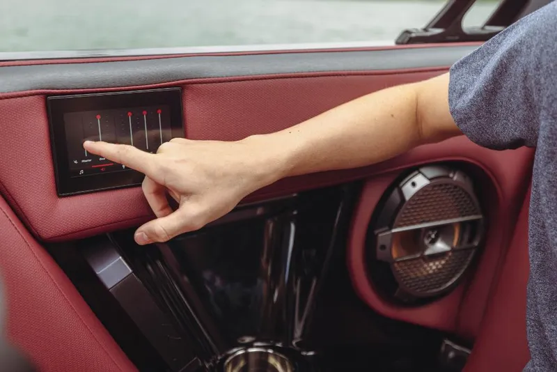Slide: The Image of Person adjusting touchscreen controls in 2023 MasterCraft XStar S boat. - 9