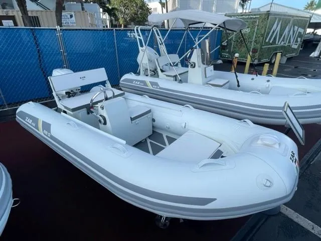 Slide: The Image of 2023 ZAR Mini RIB 12 T inflatable boat displayed at a marina. - 3