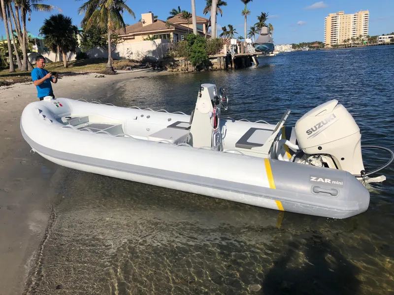 Slide: The Image of 2024 ZAR Mini RIB 16 inflatable boat on a sunny beach. - 2