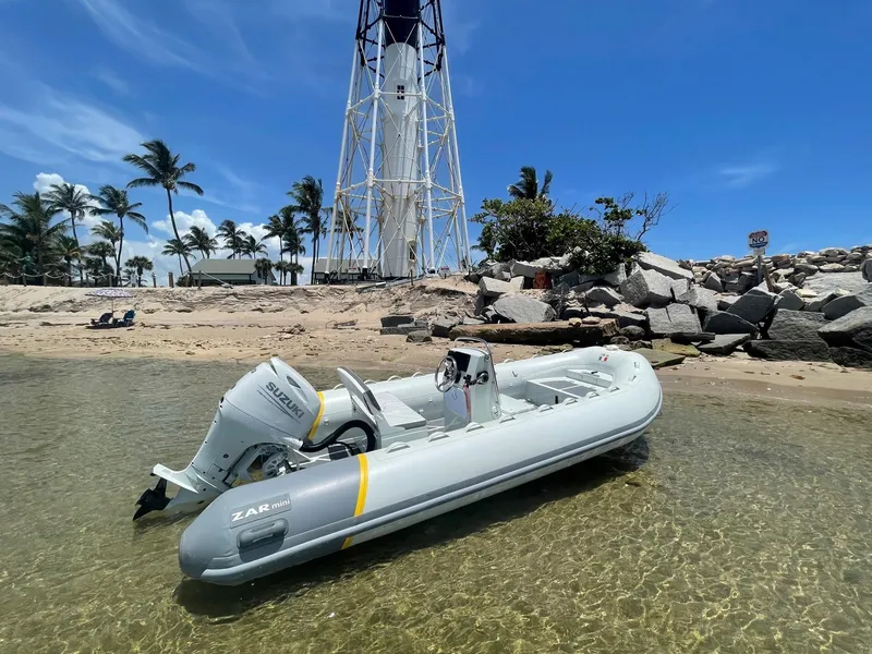 Slide: The Image of 2024 ZAR Mini RIB 16 inflatable boat on clear beach near lighthouse. - 5