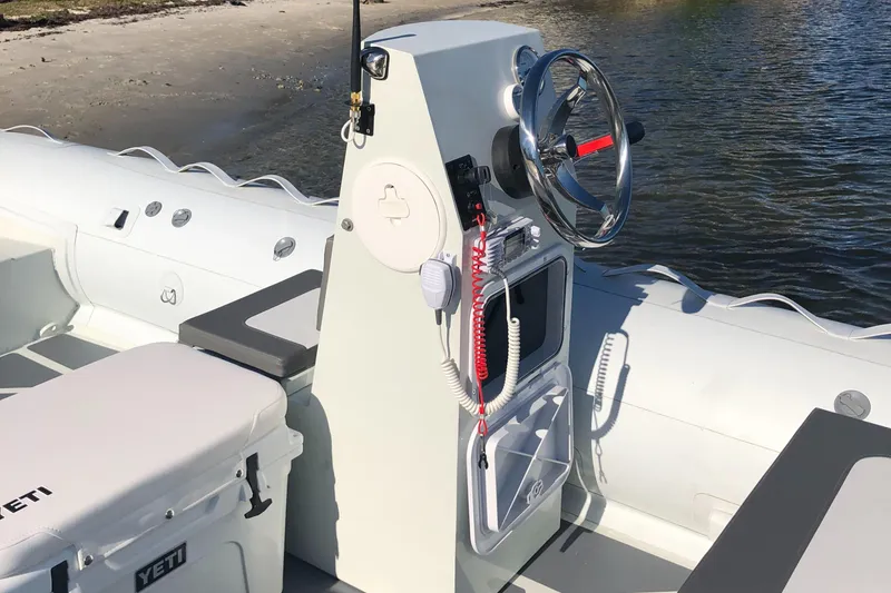 Slide: The Image of 2024 ZAR Mini RIB 16 boat console with steering wheel and storage compartments. - 6