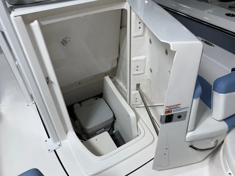 Slide: The Image of 2024 Robalo 226 Cayman boat interior storage compartment with portable toilet. - 12
