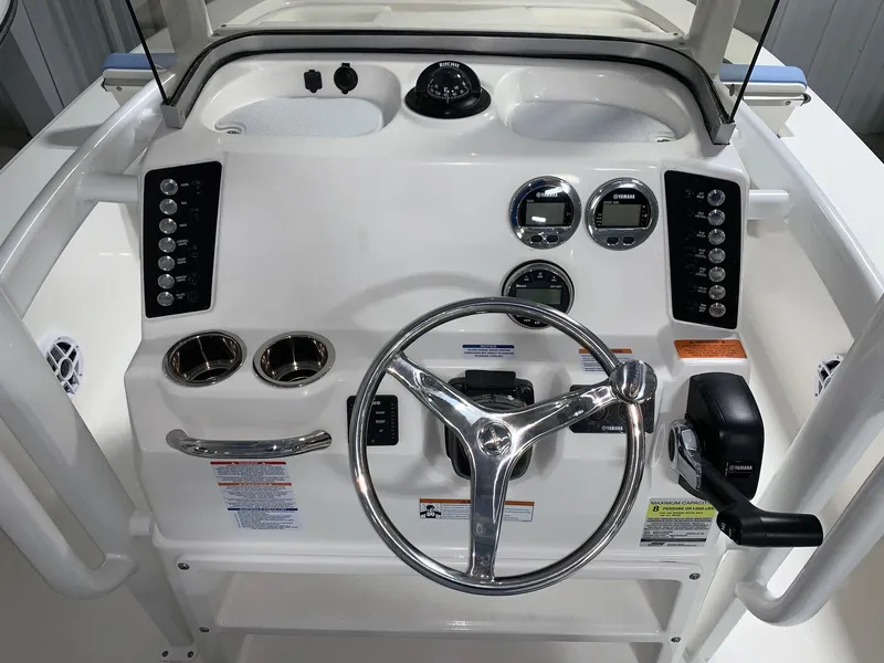 Slide: The Image of 2024 Robalo 226 Cayman boat dashboard with steering wheel and control panel. - 4