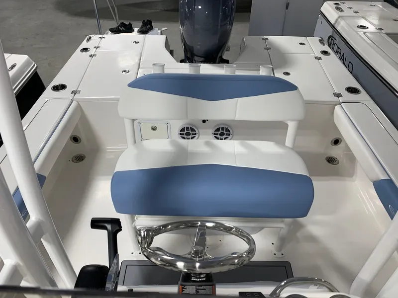 Slide: The Image of 2024 Robalo 226 Cayman boat interior with blue and white seating and steering wheel. - 5