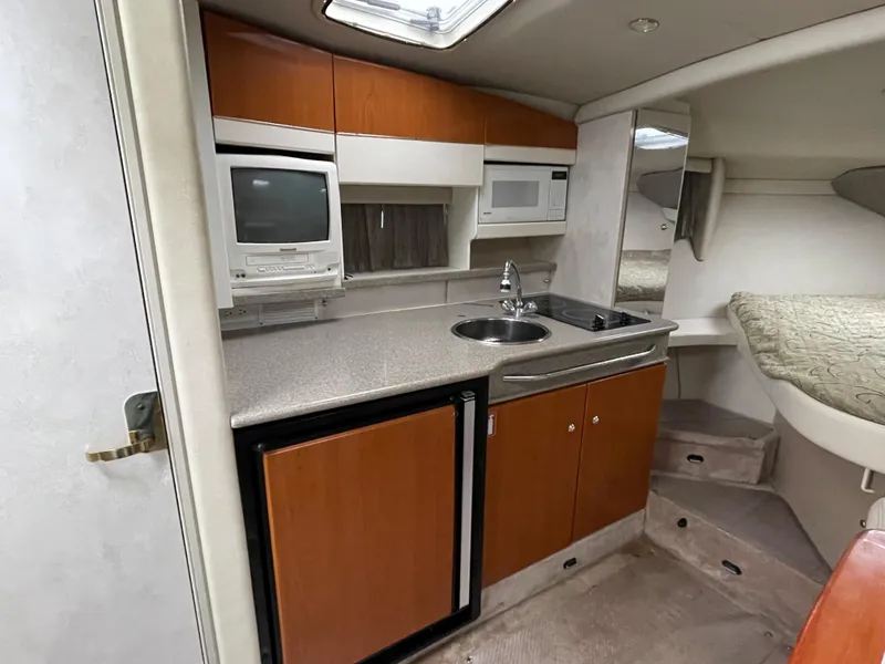 Slide: The Image of 2002 Formula 31 PC boat interior kitchen with sink, microwave, and fridge. - 11
