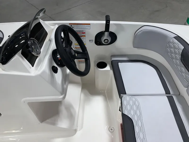 Slide: The Image of 2024 Bayliner Element M15 boat interior with steering wheel and seating. - 7