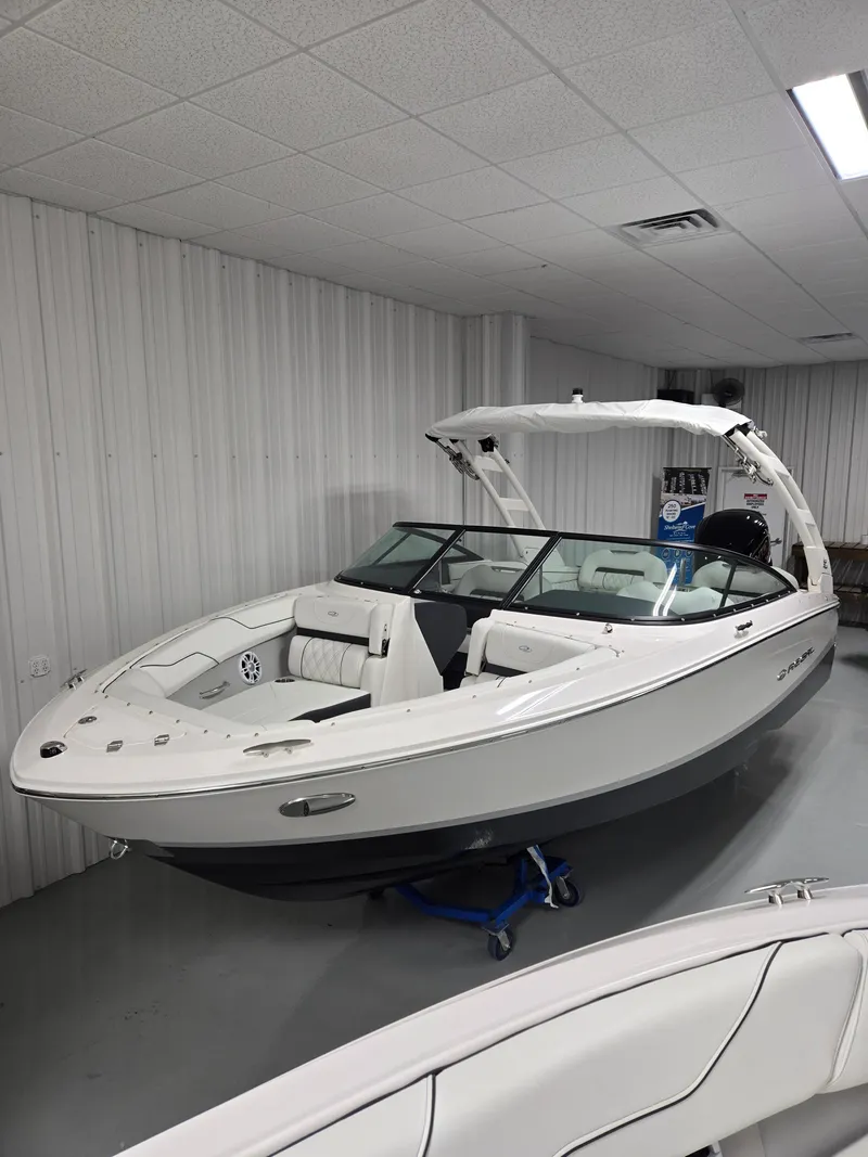 Slide: The Image of 2025 Regal LX2 boat in a showroom, featuring sleek white design and modern amenities. - 8