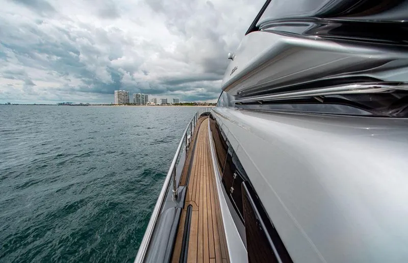 Slide: The Image of Side view of 2017 Riva 88 Domino Super yacht cruising near a coastal city. - 11