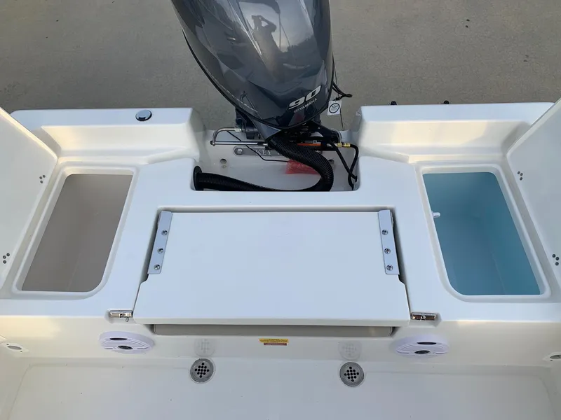 Slide: The Image of 2024 Key West 179 FS boat stern with storage compartments and outboard motor. - 13