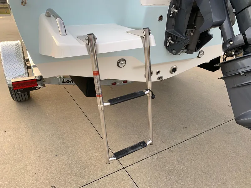 Slide: The Image of 2024 Key West 179 FS boat with a foldable swim ladder and trailer. - 14