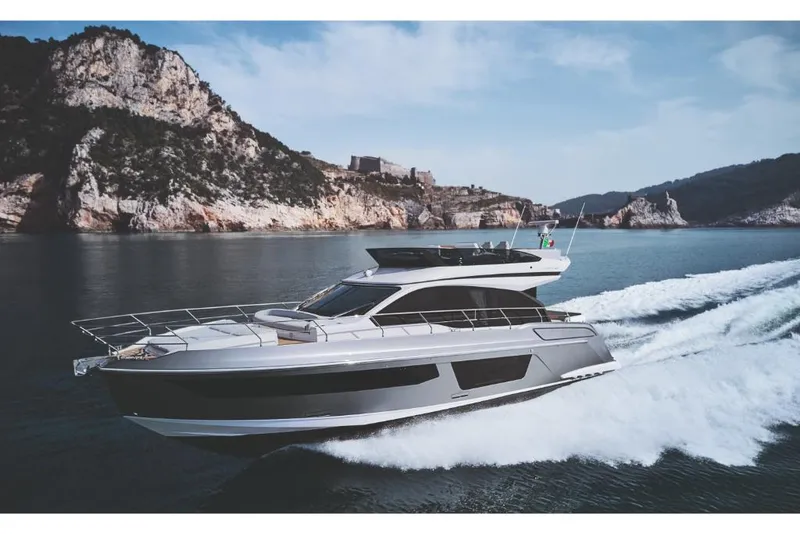 Slide: The Image of 2023 Azimut 53 yacht cruising near rocky coastline. - 0