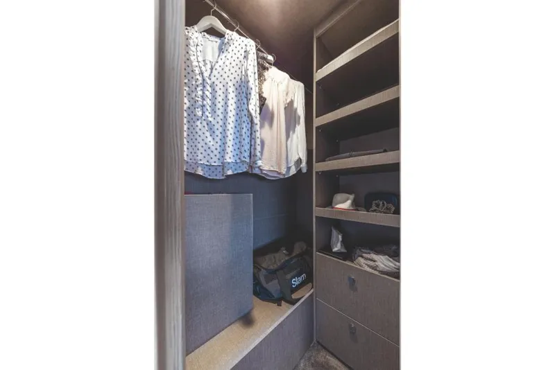 Slide: The Image of 2023 Azimut 53 yacht closet with hanging clothes and shelves. - 29