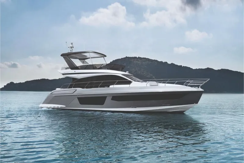 Slide: The Image of 2023 Azimut 53 yacht on calm waters with scenic mountain backdrop. - 4