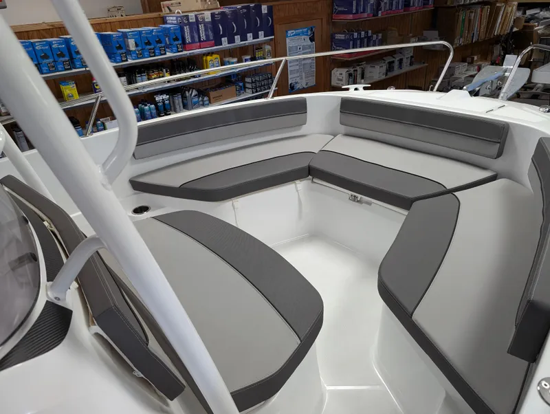 Slide: The Image of 2023 Jeanneau Leader 6.5 S3 CC boat interior with gray seating in a showroom. - 6