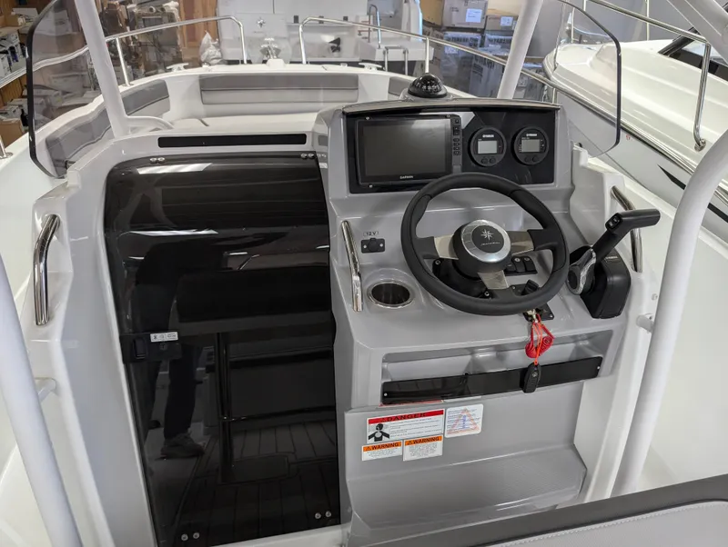 Slide: The Image of 2022 Jeanneau Leader 6.5 S3 CC boat cockpit with steering wheel and control panel. - 10