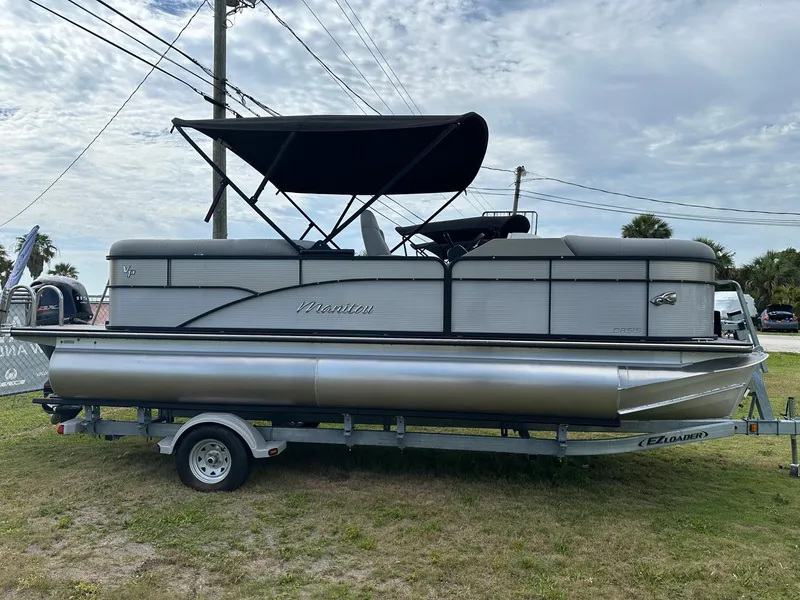 Slide: The Image of 2022 Manitou Oasis 21 RF VP pontoon boat on trailer with canopy. - 3
