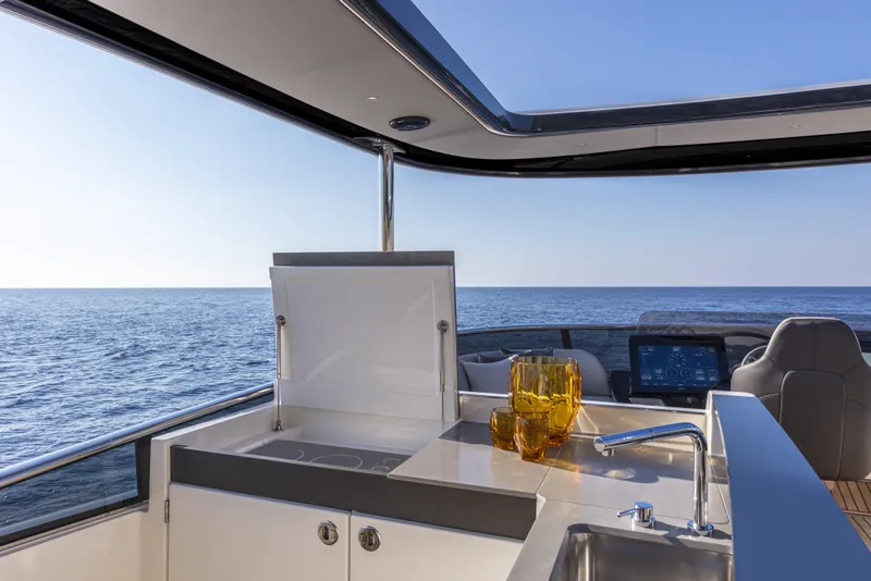 Slide: The Image of Luxurious Absolute Navetta 64 yacht interior with ocean view, featuring modern kitchen amenities, 2025 model. - 11