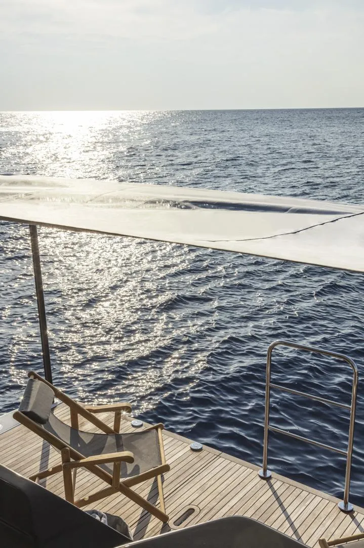 Slide: The Image of Absolute Navetta 64 yacht deck overlooking serene ocean, 2025 model. - 7