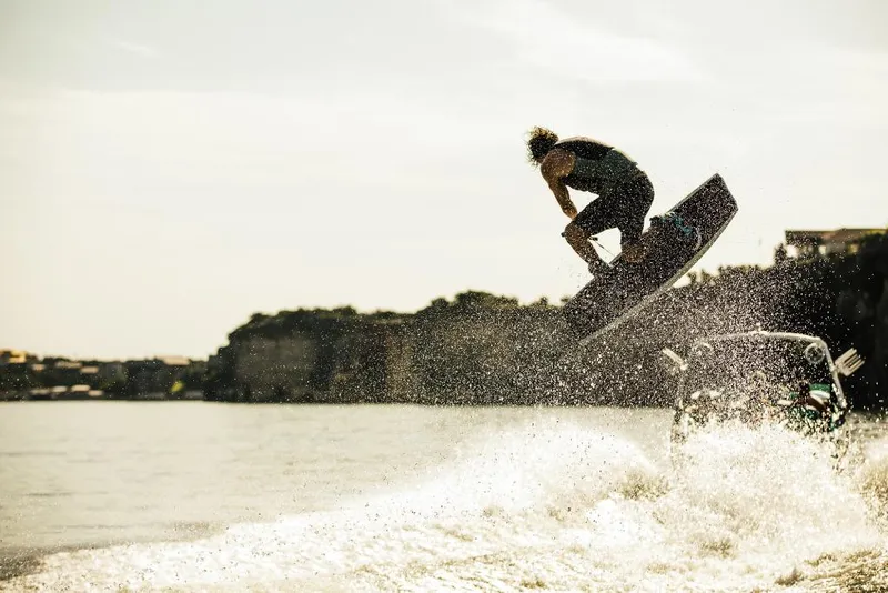 Slide: The Image of Wakeboarder performing a jump behind a 2023 Tigé 24RZX boat. - 18