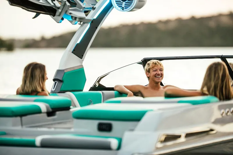 Slide: The Image of People enjoying a ride on a 2023 Tigé 24RZX boat at sunset. - 25