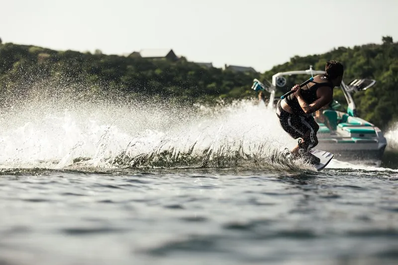 Slide: The Image of Wakeboarder riding behind a 2023 Tigé 24RZX boat on a lake. - 33