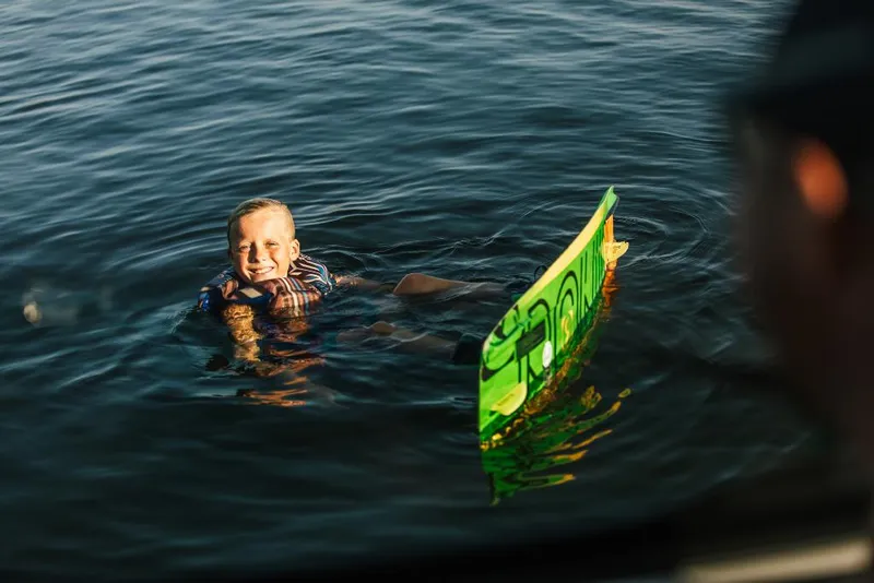 Slide: The Image of Child enjoying water activities near a 2023 Tigé 24RZX boat. - 34