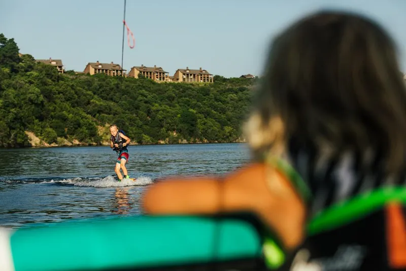 Slide: The Image of Person wakeboarding behind a 2023 Tigé 24RZX boat on a scenic lake. - 36