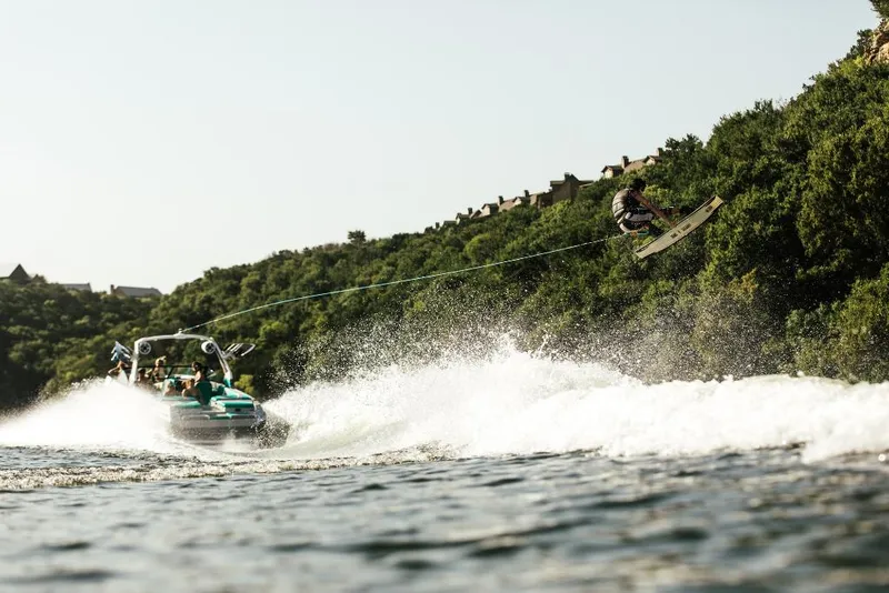 Slide: The Image of 2023 Tigé 24RZX towing a wakeboarder on a scenic lake. - 37