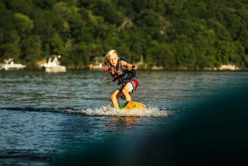 Slide: The Image of Young wakeboarder enjoying water sports behind a 2023 Tigé 24RZX boat. - 38