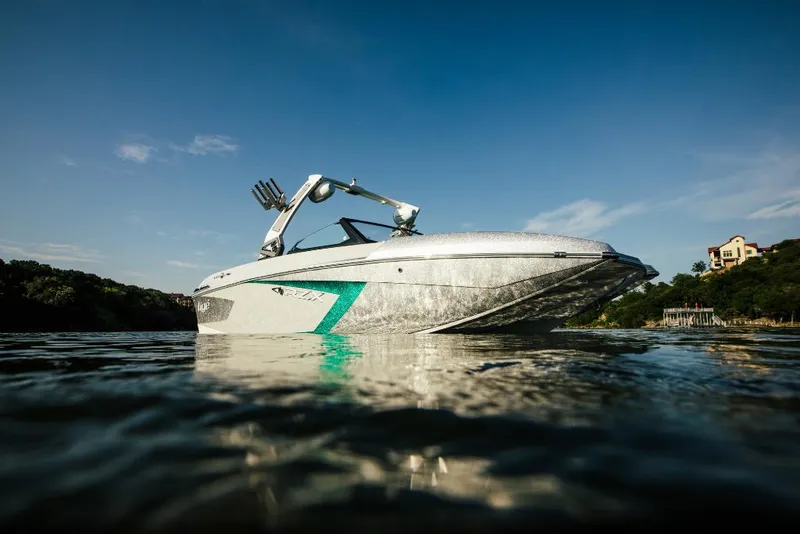 Slide: The Image of 2023 Tigé 24RZX boat on a calm lake with a clear blue sky. - 4