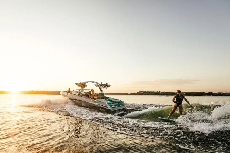 Slide: The Image of 2023 Tigé 24RZX boat towing a wakeboarder at sunset. - 42