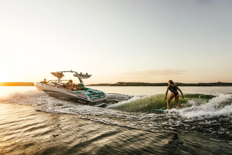 Slide: The Image of 2023 Tigé 24RZX boat towing a wakeboarder at sunset. - 44