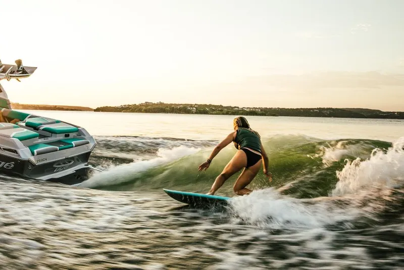 Slide: The Image of Person wakesurfing behind a 2023 Tigé 24RZX boat at sunset. - 45