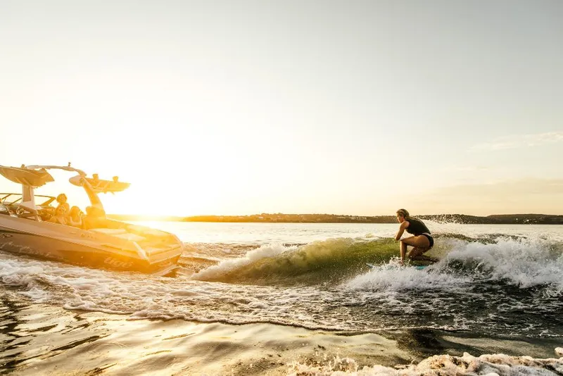 Slide: The Image of 2023 Tigé 24RZX boat towing a wakeboarder at sunset. - 46