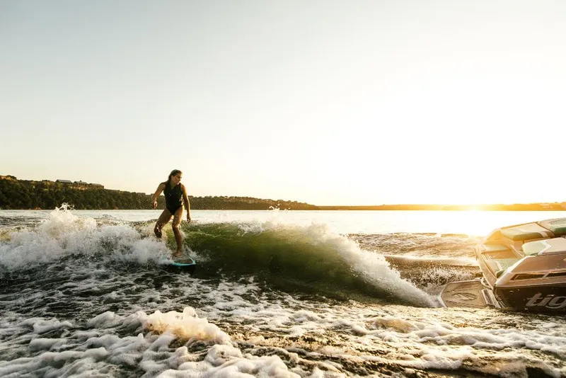Slide: The Image of Person wakesurfing behind a 2023 Tigé 24RZX boat at sunset. - 47