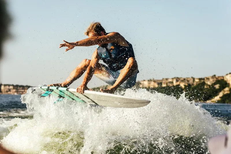 Slide: The Image of Person wakesurfing behind a 2023 Tigé 24RZX boat on a sunny day. - 48