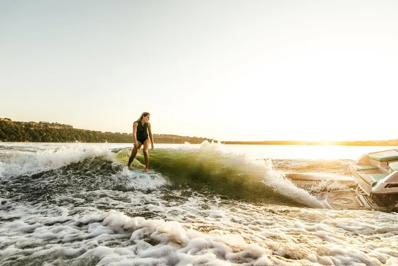 Slide: The Image of Person wakesurfing behind a 2023 Tigé 24RZX boat at sunset. - 49