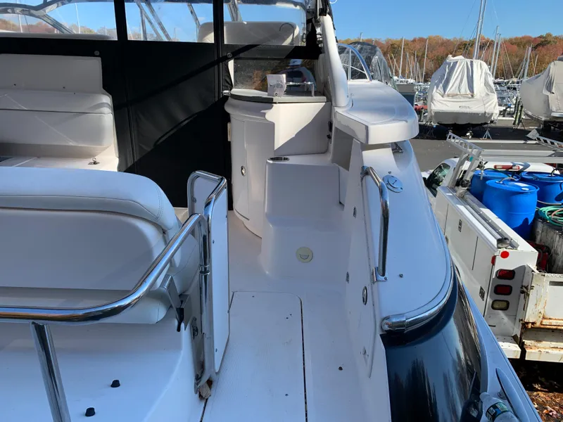 Slide: The Image of 2009 Regal 4460 yacht interior with white seating and docked boats in background. - 12