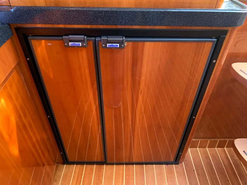Slide: The Image of 2009 Regal 4460 yacht galley with wooden cabinetry and black countertop. - 37