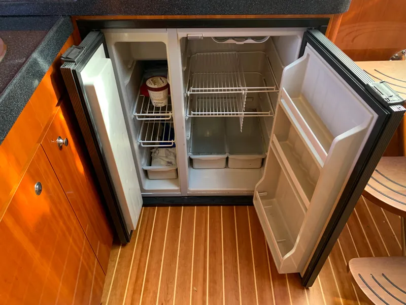 Slide: The Image of Open refrigerator in 2009 Regal 4460 boat galley with wooden flooring. - 38